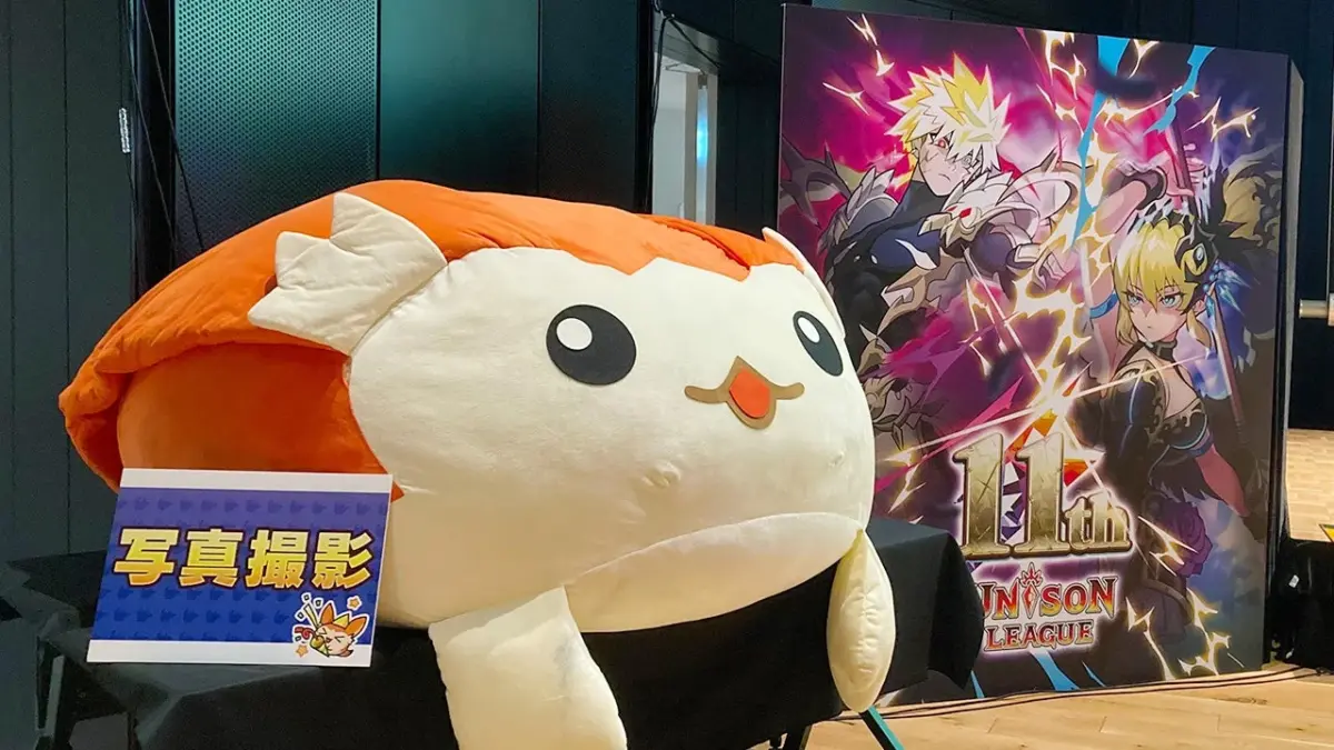 巨大なマスコットキャラクターのぬいぐるみと11周年記念パネル