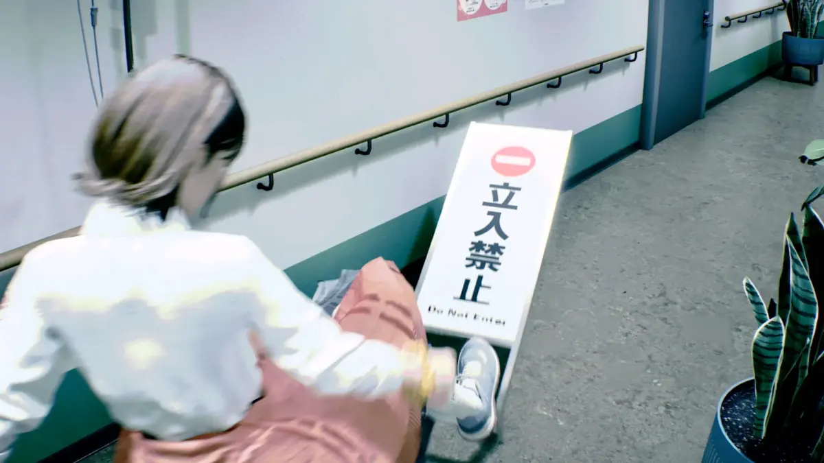 「立入禁止」の看板が置かれた廊下で座り込む人物