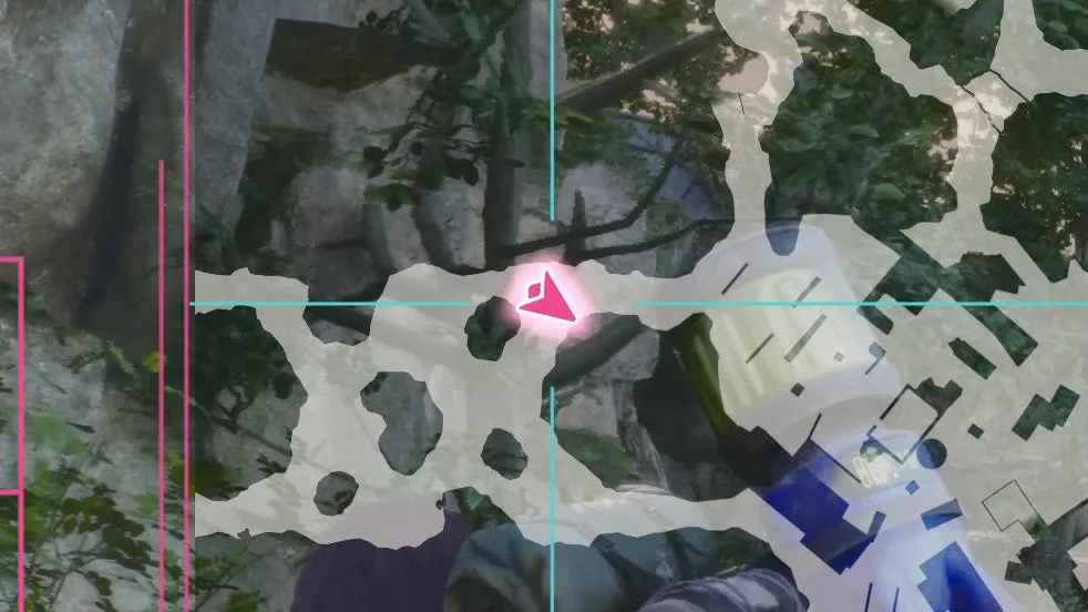 FPSゲームの画面で、岩や植物のある自然環境を背景に、ピンク色のターゲットマーカーがクロスヘアの中央に表示されている様子