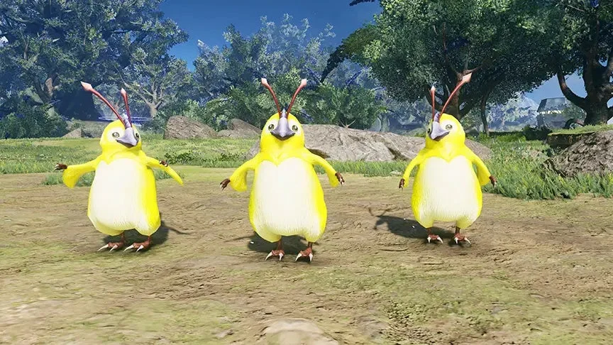 黄色い体に触角を持つ3匹の愛らしい鳥のような生き物が、緑豊かな自然の中で立っている様子