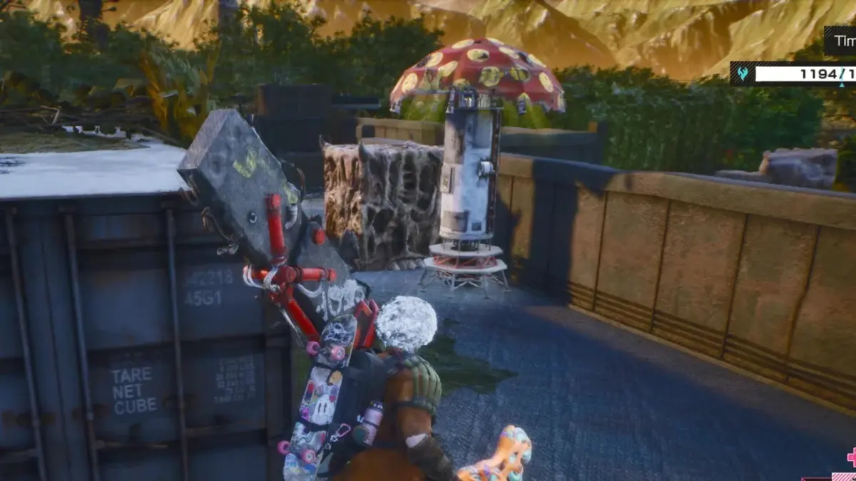 白い髪のキャラクターが巨大な武器とスケートボードを背負い、コンテナの横に立っている様子