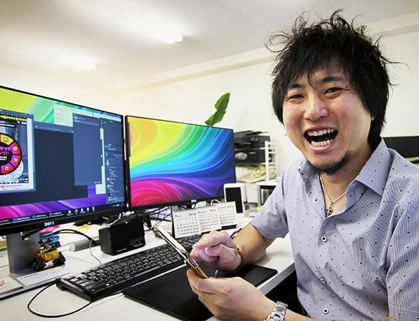 オフィスでスマートフォンを操作しながら笑顔を見せる男性