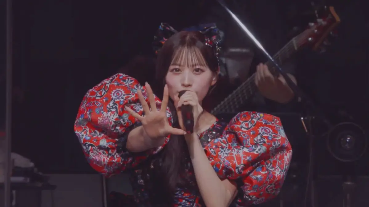 赤い衣装で歌唱する女性