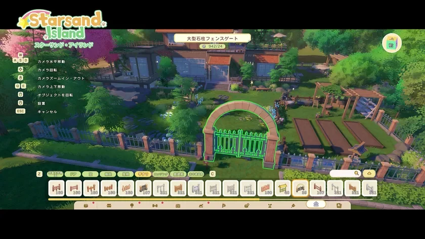 「Starsand Island」というゲームの建築画面で、プレイヤーが大型石柱フェンスゲートを設置している様子。豊かな自然に囲まれた大きな家と庭が描かれ、画面には操作ガイドや建築パーツの選択メニューが表示されている。