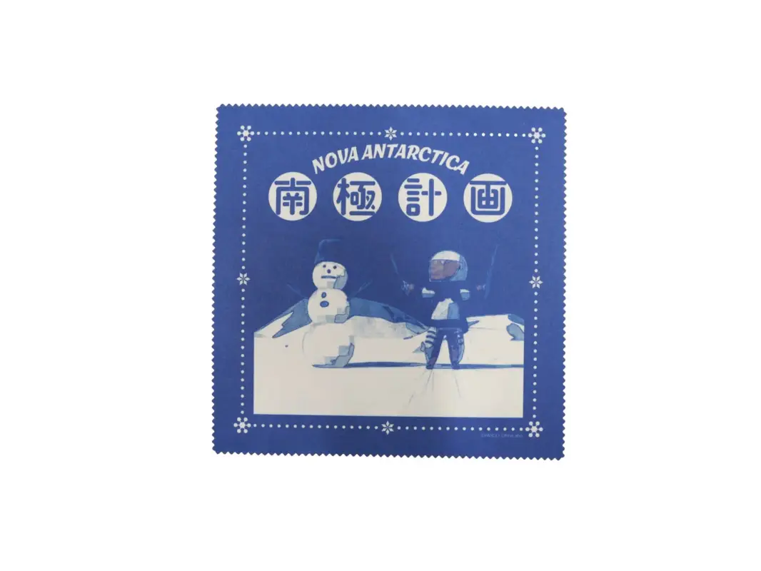 「南極計画」と「NOVA ANTARCTICA」の文字が描かれた青い布製品。雪だるまと防寒着を着た人物が雪景色の中にいるイラストが特徴。