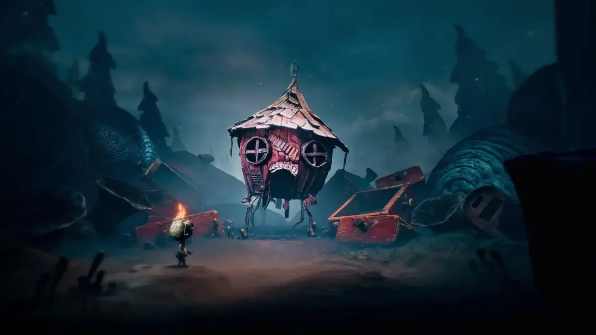 光る頭の小さなキャラクターが、足の生えた奇妙な家と対峙するダークファンタジーの世界。崩れた構造物や不気味な木々が立ち並び、幻想的でミステリアスな雰囲気を醸し出している。