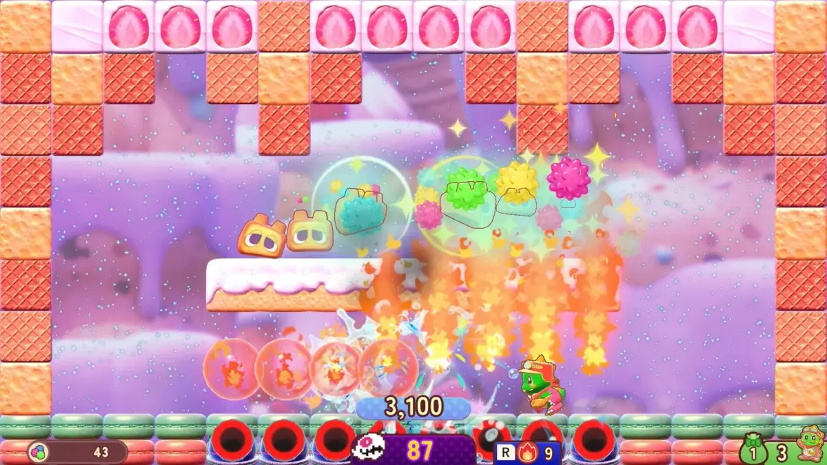 スイーツをテーマにした可愛らしいキャラクターが登場するゲーム画面です。ワッフルやいちごのブロック、マカロンが配置され、中央ではキャラクターが攻撃エフェクトを出しており、スコアや残機などのUIも表示されています。