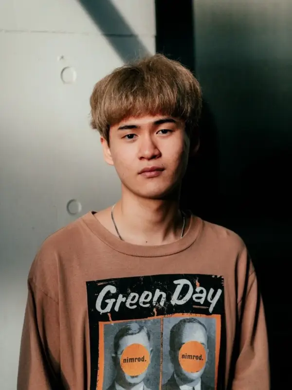 Green Dayのロゴと「nimrod.」の文字がデザインされたTシャツを着た男性